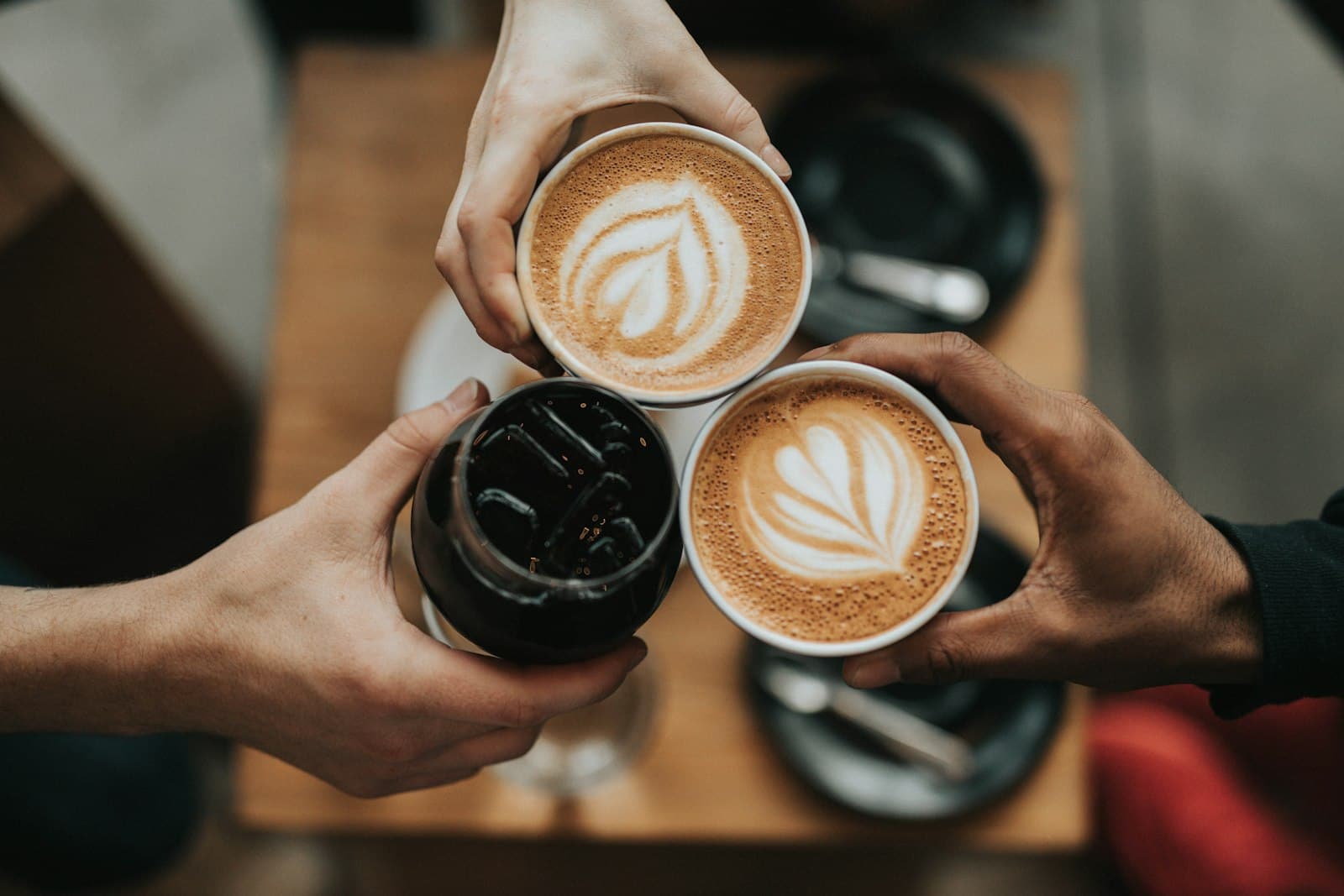 Coffee cups and beans on a kitchen counter during a weekday morning
